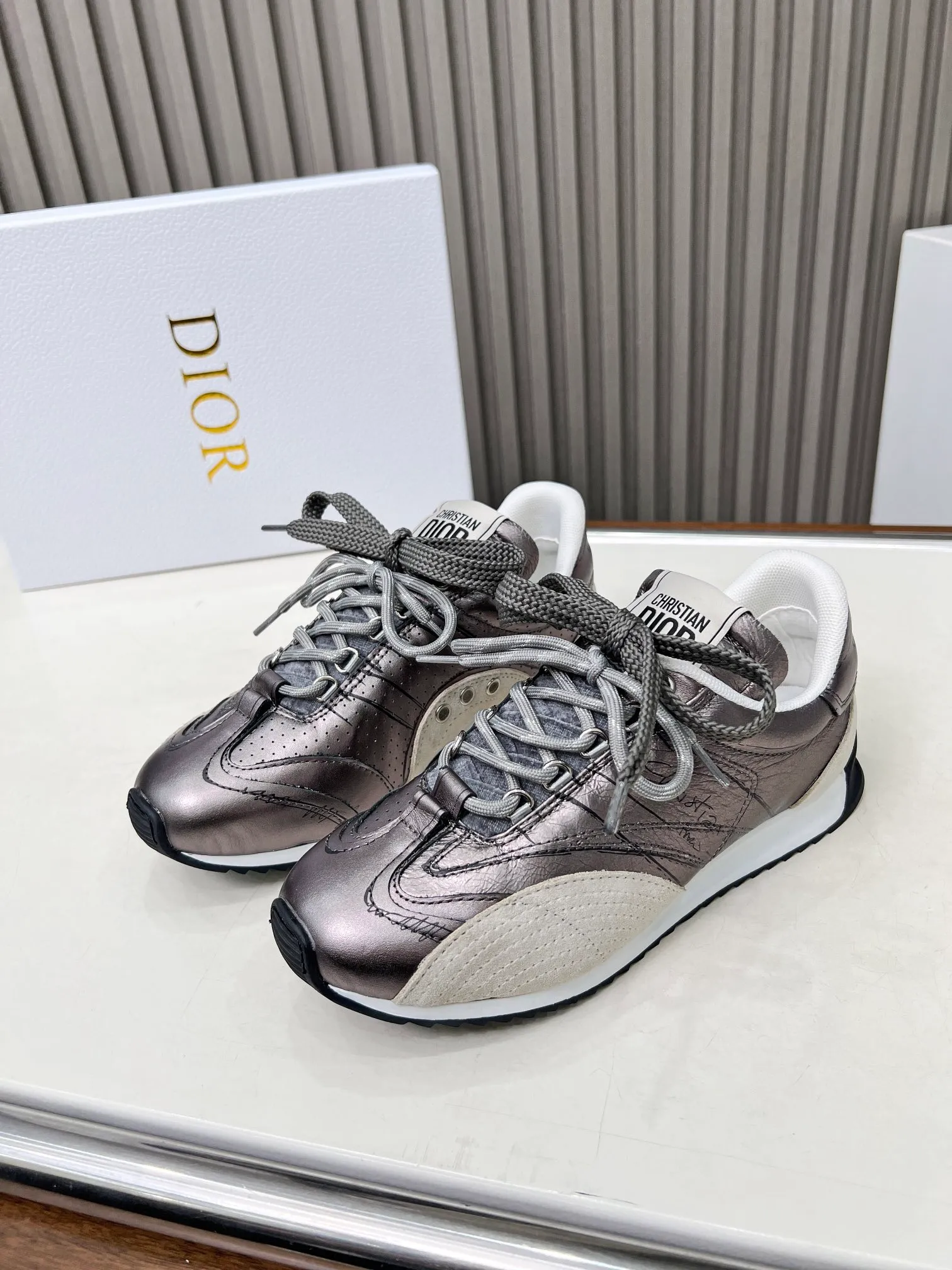 👟👟Ex-factory price 560👟👟 This D-Sketch sneaker is a new product of the 2025 spring and summer ready-to-wear series, highlighting the classic retro aesthetics. Crafted from gold-tone crinkled sheepskin and gold-toned laminated calfskin, it features a printed logo inspired by the shoe's production stages, as well as beige suede calfskin panels and double laces. Hand-written Christian Dior Paris signature on the side, Christian Dior Paris signature panels and plaques on the heel and tongue. Paired with two-tone slim rubber soles, they add a touch of couture to any casual look. Code number: 35~45 Color: black white gold silver